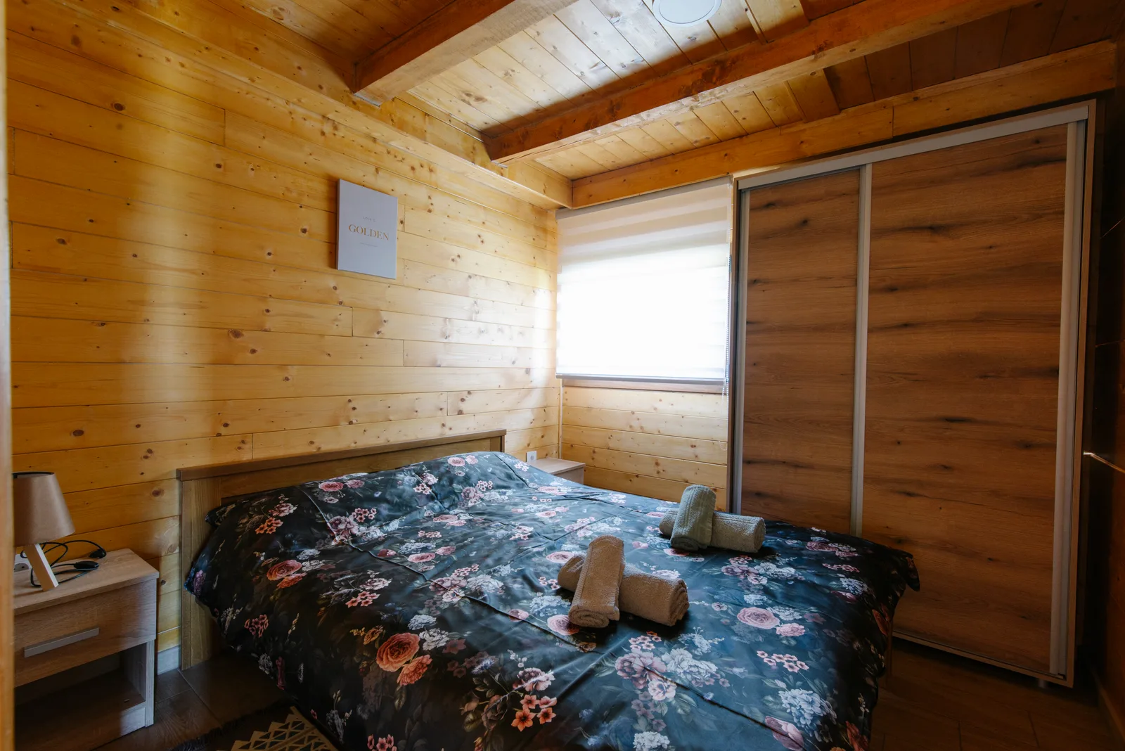 Under-bed storage containers arranged beneath a bed in a compact bedroom.
